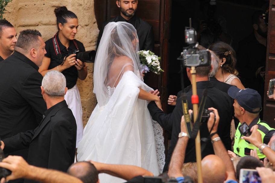 Ed ecco la sposa. Elisabetta in abito bianco saluta la folla di ammiratori che si sono dati appuntamento sul sagrato della chiesa (Olycom)